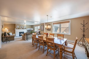 Bathed in natural light and anchored by a classic fireplace, the elegant dining room at Resort Plaza 5064 creates a warm and inviting atmosphere for shared meals and quality time together in this prem