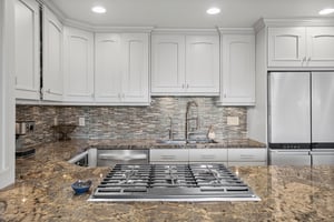 Three Kings 64 elevates the mountain lodging experience with a meticulously appointed kitchen showcasing crisp white cabinetry, a striking tile backsplash, and premium gas range that make this Park Ci