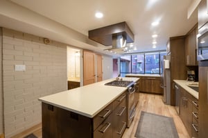 The open and thoughtfully designed kitchen at Park Avenue 256 features a generous center island, professionalgrade range, and warm wood flooring — a beautifully appointed space that elevates your Par