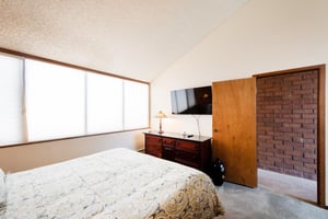 Additional view of bedroom 2  bright and comfortable bedroom at Park Avenue 267 features warm brick accent walls, and a wallmounted TV — a relaxing and characterful retreat.