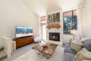 Warm tones, a glowing fireplace, and sweeping natural light make this living space at Park Avenue 299 the ultimate mountain retreat.