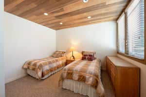 Perfect for the kids or extra guests — this charming twin bedroom at Pay Day 189 features gorgeous woodpaneled ceilings and a warm, cozy atmosphere.