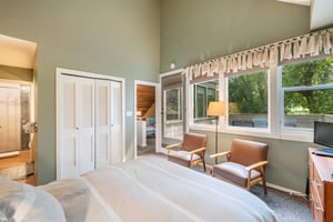 Your own private escape awaits This serene bedroom at Pay Day 183 features soaring ceilings, a cozy sitting area, and direct access to a private patio. this Park City vacation rental is perfect for y