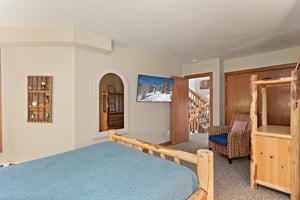 This spacious bedroom at 1296 Pinnacle features a wallmounted smart TV and plenty of room to spread out.