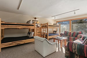 The spacious bunk room at 1296 Pinnacle features multiple beds and a cozy lounge area, making this Park City condo rental near Deer Valley Resort an ideal destination for family gatherings and group g