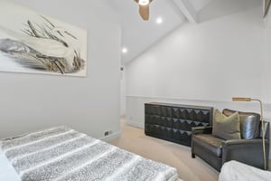 The sleek and modern loft bedroom at Three Kings 64 features soaring vaulted ceilings, leather seating, and contemporary decor that create a stylish and unique sleeping space in this exceptional Park