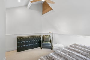 Three Kings 64 showcases its exceptional design sensibility in the loft bedroom, where vaulted ceilings, a striking geometric dresser, and carefully chosen furnishings create a stylish and inviting re