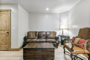 Sink into soft leather seating in your cozy living area, where rustic wood accents and warm lighting create an inviting space to unwind after exploring.