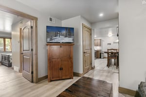 Your cozy gathering space connects the entire home with warm wood accents, a flatscreen TV for entertainment, and easy access to the bedroom and kitchen—perfect for relaxing after a day of exploring.