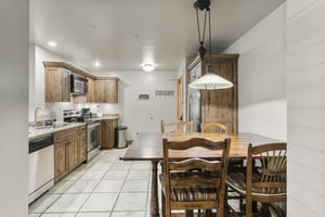 The dining area sits open to the kitchen, with a rustic wood table and granite countertops — a comfortable spot to gather for meals.