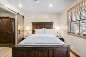 Rich wood furnishings and warm lighting give this bedroom a relaxed, comfortable feel.