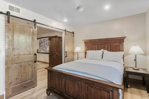 The barn door adds a rustic touch to this relaxed bedroom — a nice detail in a wellappointed Park City lodging option.