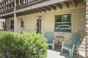 Adirondack chairs and a covered overhang make the patio a relaxed spot for morning coffee or an evening winddown.