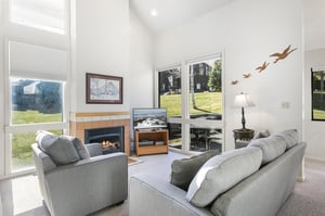 Settle into the warm and inviting living room at Three Kings 41, where a cozy fireplace, comfortable seating, and beautiful golf course views create the perfect atmosphere for relaxing in this classic