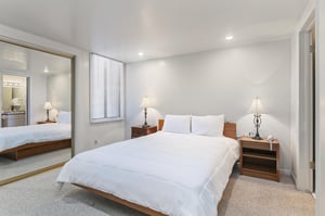 The primary bedroom offers a restful retreat with crisp linens and soft lighting — just right after a full day exploring Park City.