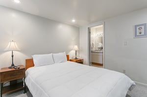 A cozy master bedroom with bedside lamps and convenient access to the bathroom.