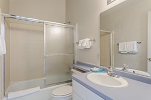 A clean, full bathroom with a glass shower and fresh towels.