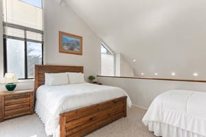 Drift off beneath vaulted ceilings in this bright, airy upstairs loft bedroom — a restful retreat in your Park City vacation rental after a full day on the mountain.. The loft offers a queen bed plus 