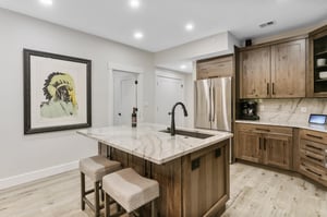 Your fully equipped kitchen features rich wood cabinetry, gleaming marble countertops, and stainless steel appliances—perfect for preparing meals or gathering with loved ones over morning coffee.