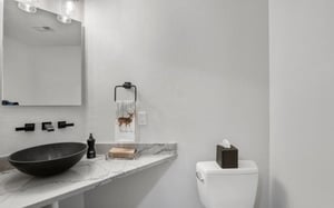 Sleek and stylish, the modern half bathroom at Powder Run C13 features a chic vessel sink and marble countertop — a polished finishing touch in this beautifully updated Deer Valley vacation rental.
