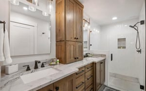 Pamper yourself in the stunning primary bathroom at Powder Run C13, featuring double sinks, luxurious marble countertops, custom wood cabinetry, and a spacious walkin shower — pure elegance in this 