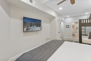 Slip into crisp linens and unwind in your bright, modern bedroom featuring mountaininspired artwork and an ensuite bathroom for ultimate comfort and convenience.