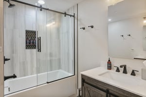 Unwind in your modern bathroom featuring sleek fixtures, marblestyle tile, and a spacious showertub combo where you can relax after a day of adventure.