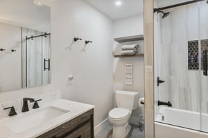 Your private bathroom features a sleek walkin shower with elegant glass doors, plush towels on floating shelves, and modern fixtures in calming neutral tones—designed for your comfort and relaxation.