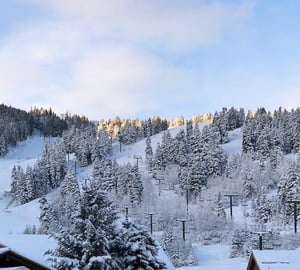Golden morning light glows over the snowcovered slopes visible right from Powder Run C13 — the perfect Deer Valley vacation rental where breathtaking Deer Valley ski run views are part of the everyd