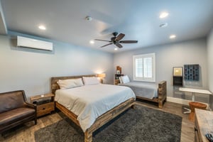 Rest and recharge in the primary bedroom at Resort Plaza 5000 — this wellappointed Park City condo rental features a king bed plus a twin bed, ceiling fan, and modern décor for a calm and comfortable