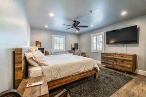 The primary bedroom at Resort Plaza 5000 offers a peaceful, private retreat with warm neutral tones, a king bed plus a twin bed — everything you need for a truly relaxing stay at this exceptional Park
