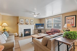 Settle in and unwind by the fireplace in the warm and inviting living room at Resort Plaza 5064, a charming Park City vacation rental that offers all the comforts of home with the beauty of the mounta