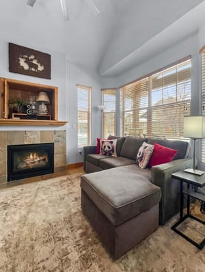 Sink into the plush sectional and enjoy the warmth of the fireplace as natural light floods this bright, welcoming space. Your perfect retreat after a day of mountain adventure.