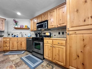 Step into your fully equipped kitchen with beautiful natural wood cabinetry, modern appliances, and plenty of counter space for preparing meals during your stay.