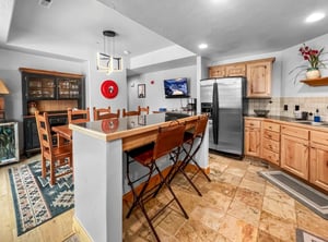 Gather around the breakfast bar for your morning coffee or prep a homecooked meal in this fully equipped kitchen with stainless steel appliances and warm wood cabinetry.