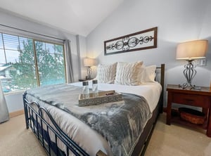 Unwind in your serene bedroom sanctuary, where soft linens and warm lighting invite you to relax. Natural light pours through the window, creating a peaceful retreat after your days adventures.