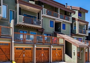 A contemporary multilevel property featuring private balconies, modern mesh railings, and convenient garage parking, offering comfortable accommodations in an inviting residential setting.