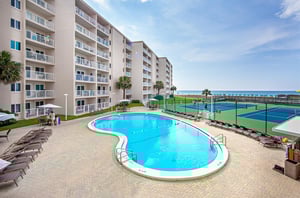 The communitys kidneyshaped pool and spacious sundeck with lots of loungers.