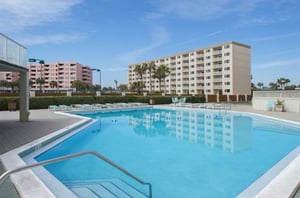 The community swimming pool and sundeck equipped with lots of loungers.