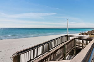 A community boardwalk and stairs leading directly to the Gulf coast.