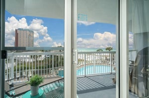 A sliding door leading to a private balcony that overlooks the Gulf and the pool deck