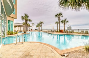 A large blue swimming pool in front of Aqua Resort in Panama City Beach Florida