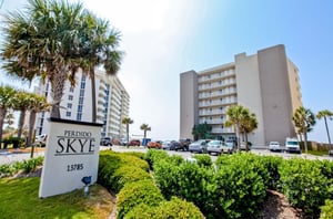View from the street of Perdido Skye and the propertys entry sign with complimentary parking in front