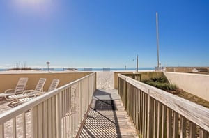 A wooden boardwalk leading to the beach and the Gulf