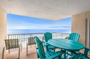 Chairs and tables on a private balcony overlooking the Gulf of Mexico