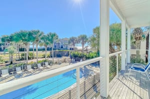 Tall palm trees and tropical landscaping surround the community swimming pool and sundeck.