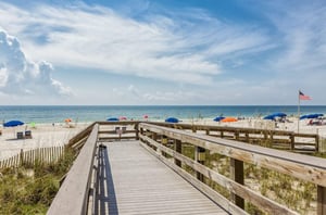 A wooden boardwalk leading to the Gulf at Pelican Pointe
