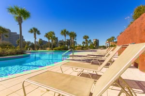 The lagoon pool and spacious sundeck dotted with towering palm trees and ample seating and loungers for guests