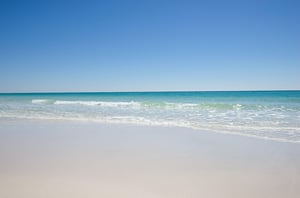 The sun shimmers on the propertys adjacent beach.