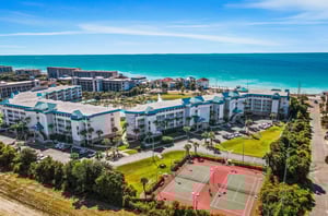 This aerial view shows the complex tennis courts and how close the property is to the beach.